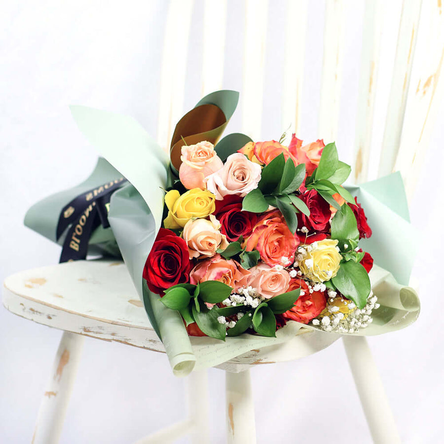 Bouquet with red, orange and yellow roses. Baby's breath and ruscus. Los Angeles Blooms