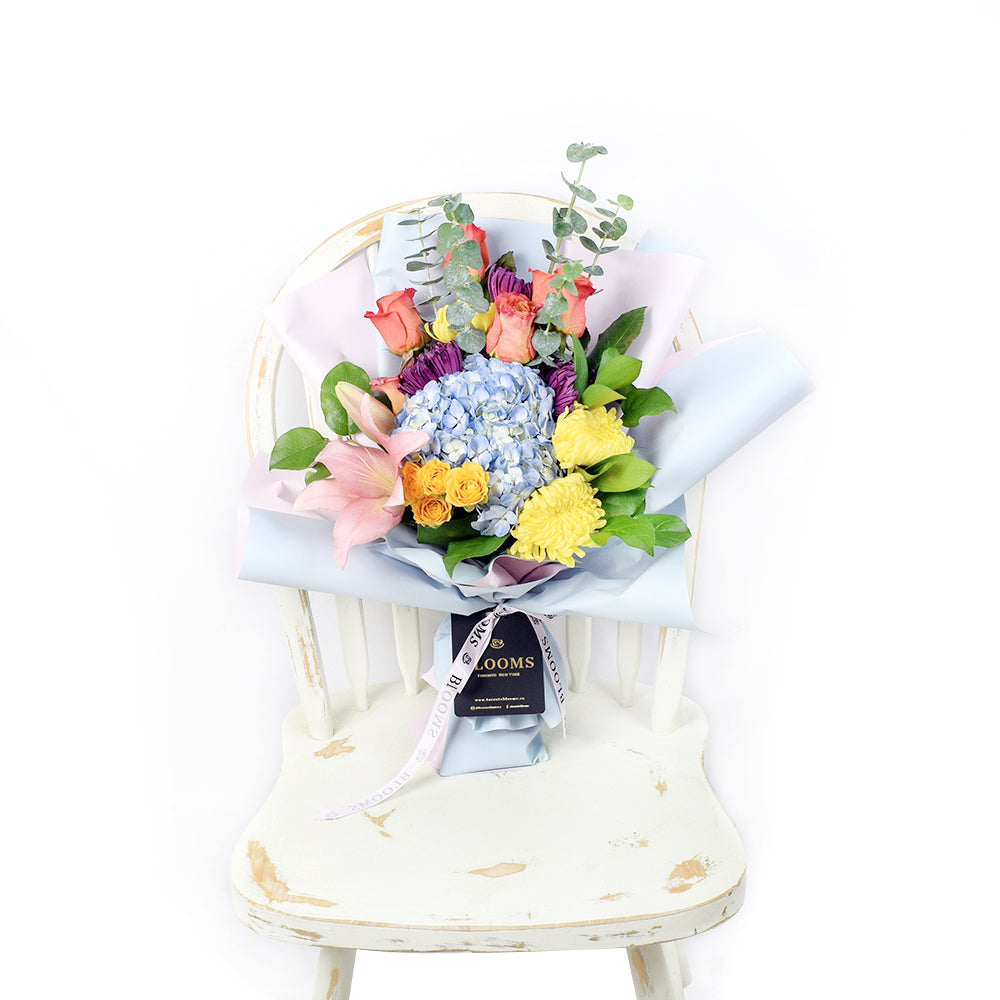 The Festive Purim Bouquet from Los Angeles Blooms features a cheerful arrangement of roses, cremons and other flowers tied with a designer ribbon